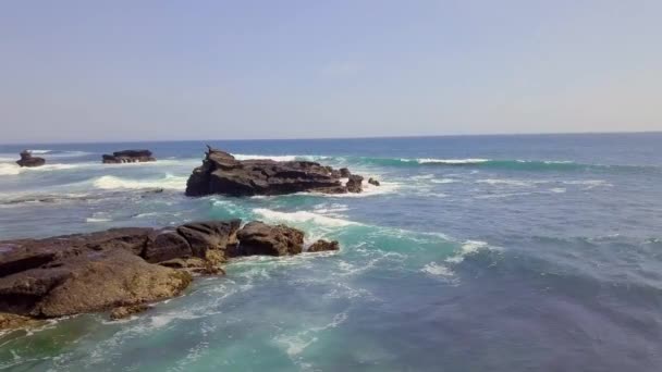 Fotografía cinematográfica de la hermosa playa costera con olas estrellándose en las rocas . — Vídeos de Stock