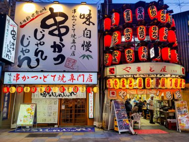 Osaka, Japonya - Mar 26 2018: Shinsekai Pazar ünlü restoran ve perakende mağazaları ve Simgesel Yapı Tsutenkaku Kulesi Osaka ile sokak bizim gecemiz.