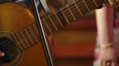 Yetişkin adam bir akustik gitar çalmak. Kamera çubuğu hareket eder..
