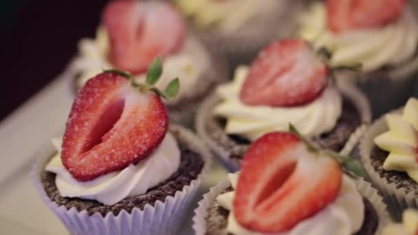 Muffins con la mentira de la fresa en la barra de caramelo, primer plano — Vídeo de stock