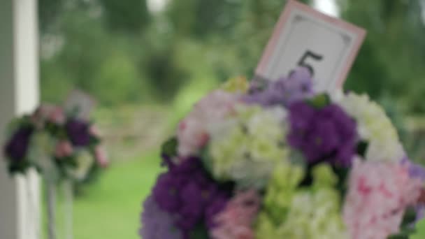 Casamento com mesas numeradas flores amarelas, brancas, rosa e lavanda . — Vídeo de Stock