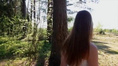 Kırmızı dudaklar ile seksi kız ormanda bir güneşli yaz gününde güneş gözlüğü içinde yürür.