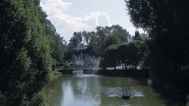 Baba oğlu ile yeşil bir park gölde bir teknede yelken.
