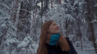 Kız kış ormanda yürüyüş. O etrafında manzarayı etrafında görünüyor