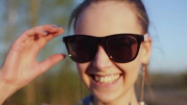 Kameraya gülümseyen genç, şık, gayri resmi kız