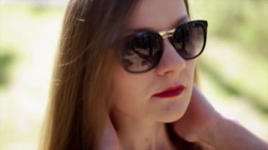 Kırmızı dudaklar ile güneş gözlüklü kız güzel genç moda uzun saç düzeltir.