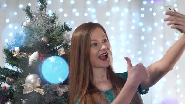 Gyönyörű divatos lány piros ajkak fényképezett öltözött fel a karácsonyfa háttér — Stock videók