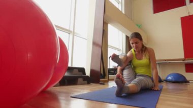 Spor, sevimli kız bir hareketten Ashtavakrasana asan gerçekleştirir.