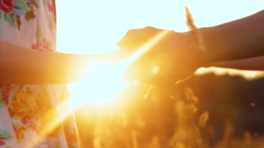 Güzel genç çift elele günbatımında güneş ışınları