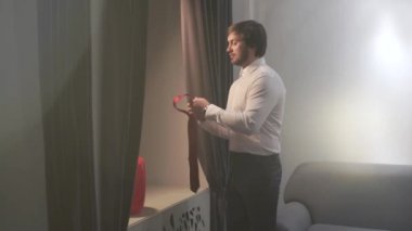 Acımasız yakışıklı adam düğün günü içinde giyinmiş. Damat pencereye gider, o onun boynuna kırmızı kravat koyar. Kamerayı sola taşır. Çerçeve ışık dolu. Büyük gün.