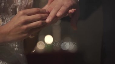 Gelin parmağına alyans damat mum, muhteşem bir konumda için giyer yakın çekim. Arka planda hafif bir bokeh daireler. Büyük gün.