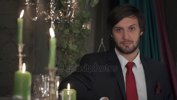 촛불으로 로맨틱 한 분위기에 빨간색 넥타이와 양복에 잔인 한 수염된 남자의 초상화. — 비디오