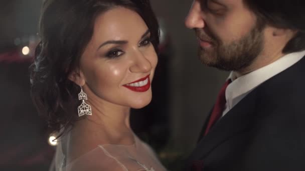 Verbazingwekkend mooie vrouw met rode lippen glimlachend in het algemeen, als haar man haar zachtjes hugs — Stockvideo