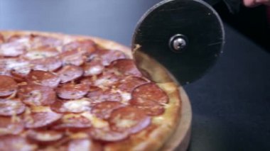 Salamlı pizza pizza için özel bir bıçakla ikiye böldüm.
