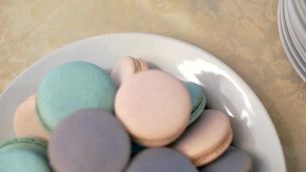La cámara se mueve sobre el plato con macarrones de colores — Vídeo de stock