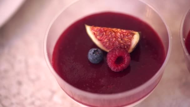 Postre de frutas, decorado con una rebanada de pomelo, arándanos y frambuesas de cerca — Vídeo de stock