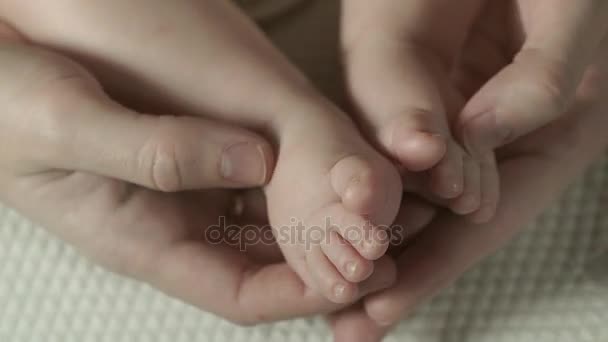Madre sta toccando e accarezzando i piedi del bambino . — Video Stock