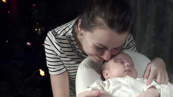 Mamá con amor mira a su bebé, acariciando su mano toca la nariz y las mejillas — Vídeos de Stock