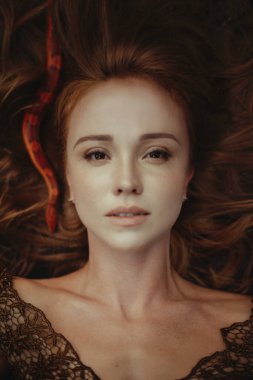 Turuncu yılanlı güzel kızıl saçlı kadın.