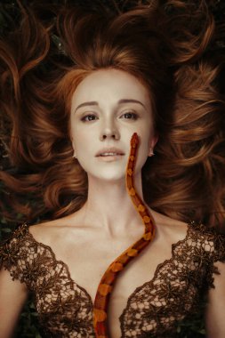 Turuncu yılanlı güzel kızıl saçlı kadın.