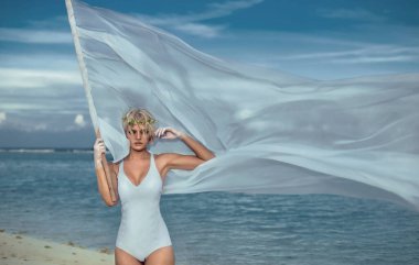 Kumsalda beyaz bayrağı olan güzel bir kadın.