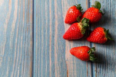 Sulu, güzel organik çilekler mavi arka planda..