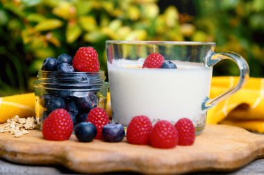 Sağlıklı bir kahvaltı yapıyorum. Yoğurt, granola, chia tohumu, taze ve kuru meyve, yaban mersini, şeffaf ahududu. Temiz yemek, diyet, detoks, vejetaryen gıda konsepti.