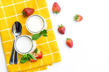 Nane ve çilekle süslenmiş beyaz arka planda iki bardak doğal yoğurt..