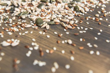 Keten tohumu, ayçiçeği, balkabağı, tahtadan bir arka planda susam tohumu. Üst Manzara. Fotoğraf seçici bir odak ile çekildi.