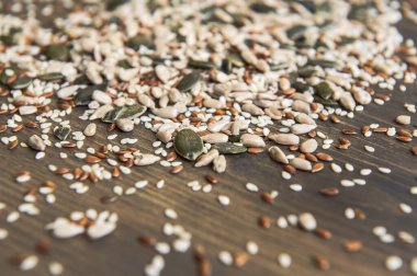 Keten tohumu, ayçiçeği, balkabağı, tahtadan bir arka planda susam tohumu. Üst Manzara. Fotoğraf seçici bir odak ile çekildi.