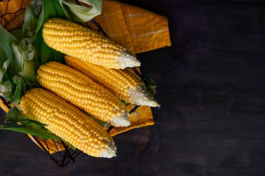 Kırsal ahşap bir masada sepette taze mısır, yakın plan..