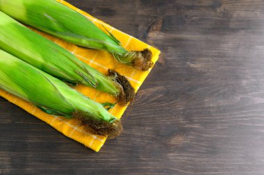 Koçanda mısır - Tahta arka planda taze mısır kulağı.