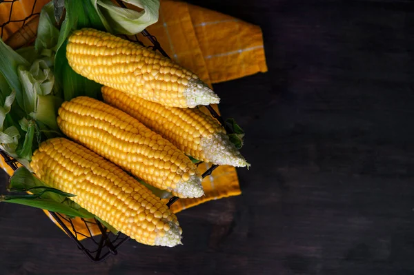 Kırsal ahşap bir masada sepette taze mısır, yakın plan..