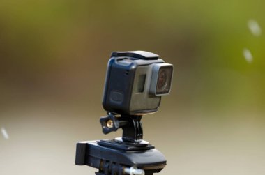 Aksiyon kamerası, karlı ve çimenli bulanık bir arkaplanda bir nehir ile video kaydediyor..