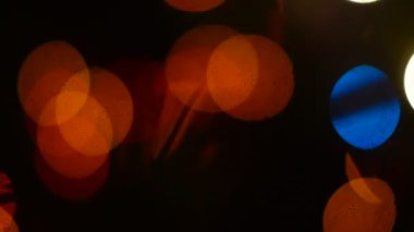 Çok renkli parlak parlak ışık çelenkleri karanlıkta yanıp sönen çok renkli ışık köknar iğnelerinin siluetleriyle Noel gecesi. Bokeh.