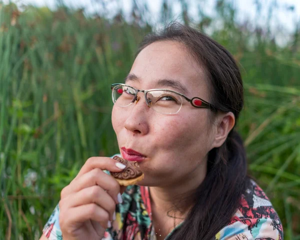 Smiling Asian Yakut Girl Glasses Sitting Grass Eating Cookies Flying — Stock Photo, Image