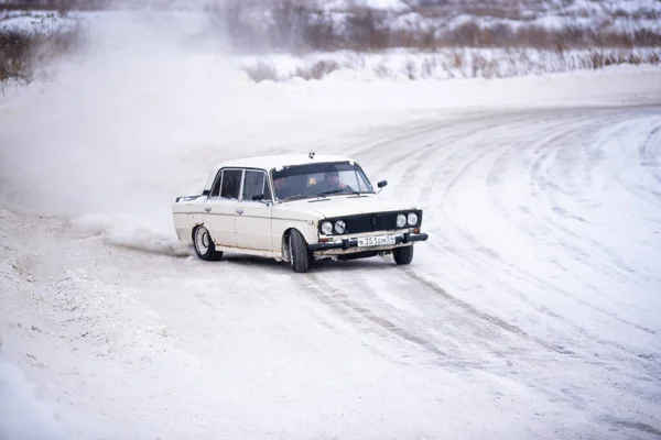 俄罗斯 Novosibirsk 2019年11月30日 俄罗斯白色小车 Vaz Zhiguli 在漂流中快速侧向行驶 在转弯时与两名男子一起下雪 — 图库照片