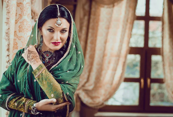 Portret van een mooie vrouw in Indiase traditionele Chinese jurk, met haar handen beschilderd met henna mehendi. — Stockfoto