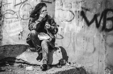 Evsiz dilenci stilzhizni, sağlık, sosyal kontsept-yorgun, sefil evsiz aç kadın sigara içiyor