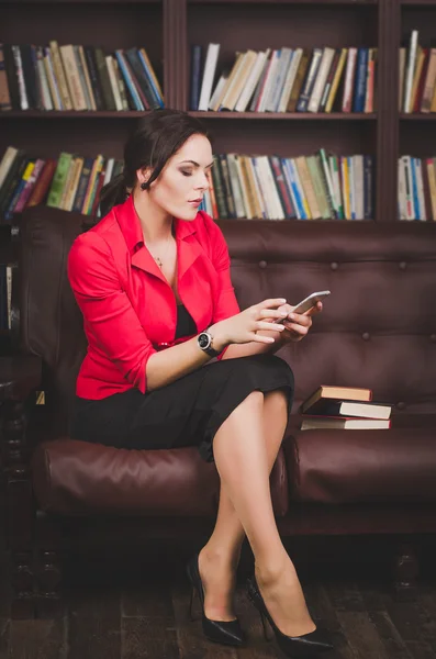 Attrayant femme d'affaires en vêtements de bureau assis sur un cuir — Photo