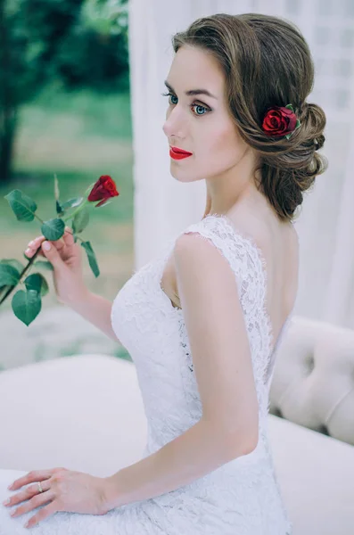 Retrato de una joven novia feliz con una rosa roja en las manos — Foto de Stock