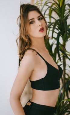 Kısa bir siyah bluz ve kot tezgahı duvar genç bir kadın