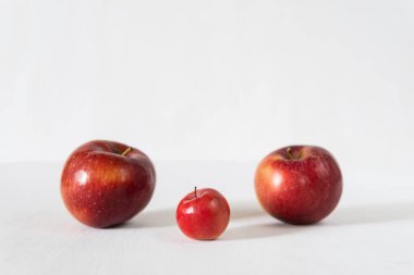 Kırmızı arkaplanda bebek elması olan ebeveyn elmaları