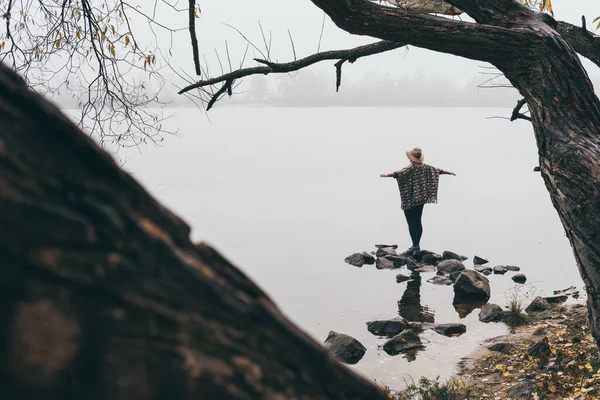 Vrouw silhouet op de oever van de rivier in de ochtend mist — Stockfoto