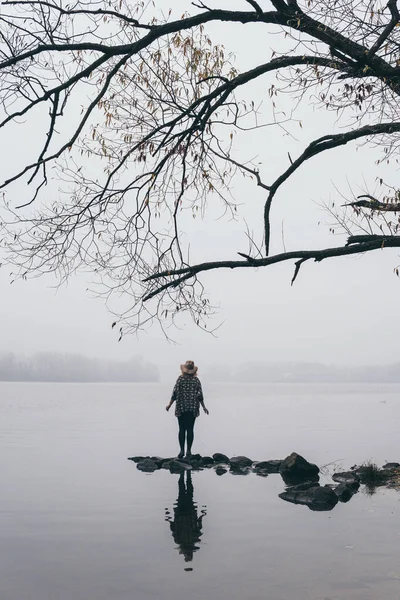 Vrouw silhouet op de oever van de rivier in de ochtend mist — Stockfoto