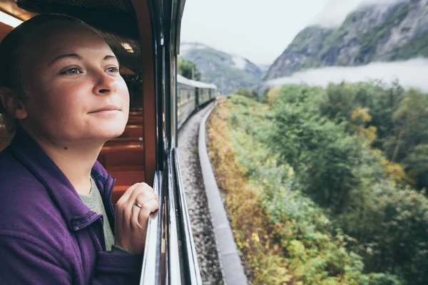 Donna che si gode un giro e guarda fuori dalla finestra sulla ferrovia di montagna Flamsbana a Flam, Norvegia — Foto Stock