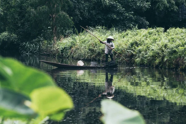 Ninh Binh, Vietnam - Maggio 2019: Vietnamita in una barca a remi di legno pesca a Trang Un parco naturale — Foto Stock