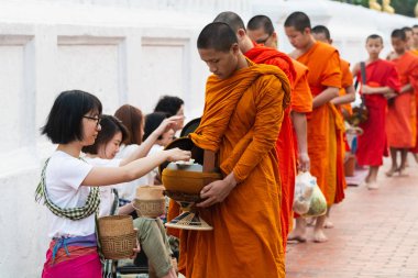 Luang Prabang, Laos - Mayıs 2019: Laos 'lu kadın Budist rahiplere sadaka töreni sırasında adak adadı