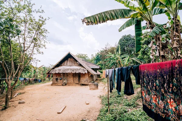 Čerstvě vysušení prádla před tradiční Laoské bambusovou chýší ve vesnici poblíž Nong Khiaw, Laos — Stock fotografie
