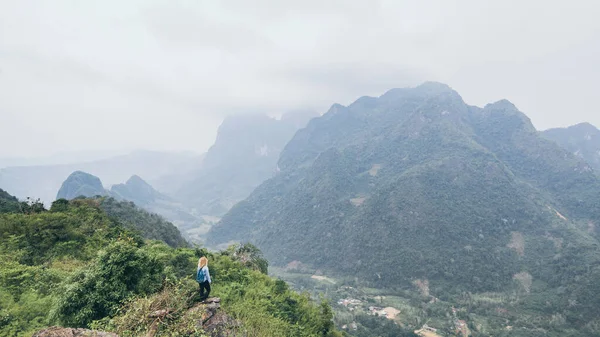 Jeune femme caucasienne debout sur le sommet de la montagne surplombant la vallée de la rivière dans le village de Nong Khiaw, Laos — Photo